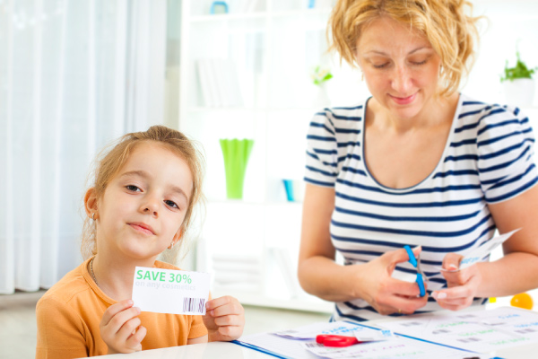 Mother and daughter cutting coupons. Mother and daughter cutting coupons.